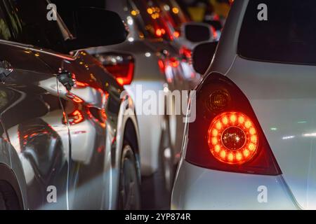 Rücklicht eines weißen Autos, das in der Nacht in der Stadt ansteht. Stockfoto
