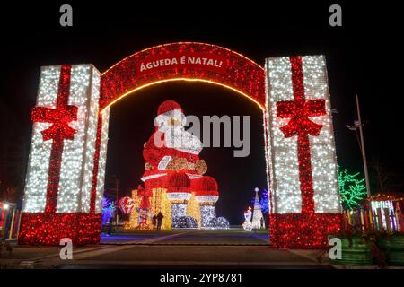 Águeda, Portugal - 27. November 2024: Nächtlicher Blick auf die Weihnachtslichter des größten Weihnachtsmanns der Welt, umrahmt vom Eingang zum Gehege Stockfoto