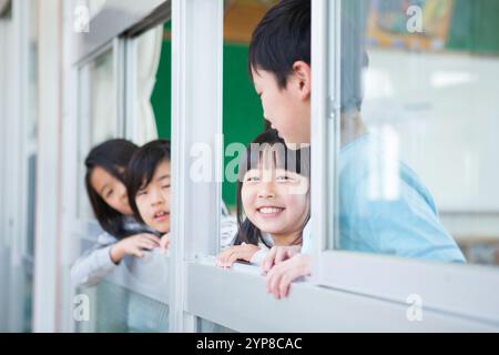 Schulkinder, die aus dem Fenster schauen Stockfoto