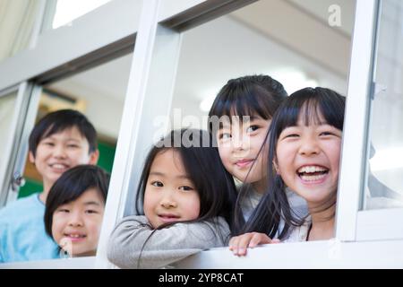 Schulkinder, die aus dem Fenster schauen Stockfoto