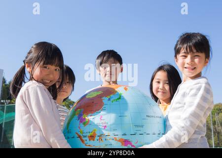 Grundschulschüler, der einen Globus hält Stockfoto