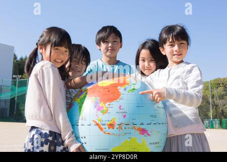 Grundschulschüler, der einen Globus hält Stockfoto