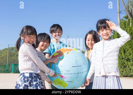 Grundschulschüler, der einen Globus hält Stockfoto