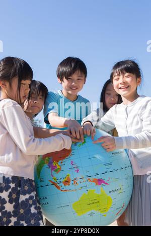 Grundschulschüler, der einen Globus hält Stockfoto