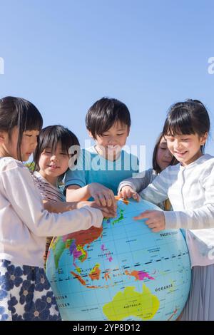 Grundschulschüler, der einen Globus hält Stockfoto