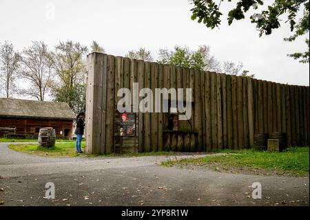 Eine Person öffnet das abgeschnittene Fenster in der Palisadenwand von Fort Langley (1827), einem Pelzhandelsposten und einem Zentrum für Tauschgeschäfte mit den Ureinwohnern. Stockfoto