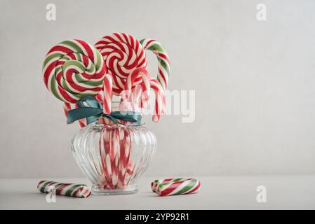 Weihnachtsbonbons, Lutscher und Marshmallows in einem Glas auf hellem Hintergrund Stockfoto