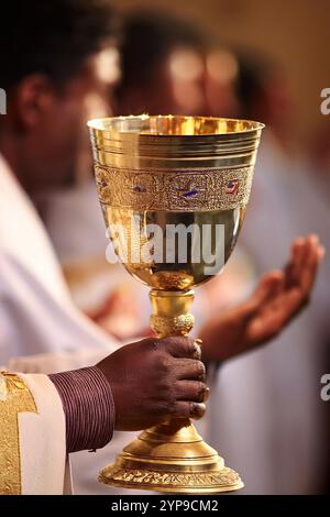 Eucharistische Partikel in den Händen des Pfarrers in der Kirche Stockfoto