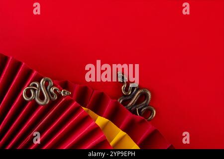 Chinesisches asien Neujahr goldener roter Hintergrund. Neue Grußkarte für das Jahr der Schlange 2025 mit Sternzeichen. Roter flacher Hintergrund mit Weihnachtsfans, Wunschumschläge, sn Stockfoto