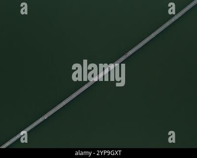 Fischer auf einer Brücke über einen See von oben, Blick auf die dron Stockfoto