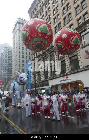 1 Herald Square, New York, NY 10001, USA. November 2024. Widerstandsfähige, aber durchweg durchnässte New Yorker trotzten einem unerbittlichen Eisregen im Atlantik, um die 98. Jährliche Macy’s Thanksgiving y Parade zu feiern, die in diesem Jahr 22 riesige Ballons, 34 ausgeklügelte Wagen, 7 Radballons, 11 Marchng Bands und 700 Clowns beinhaltete. Quelle: ©Julia Mineeva/EGBN TV News/Alamy Live News Stockfoto