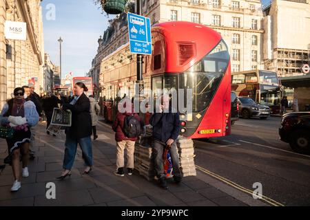 Auf der Straße entlang Piccadilly, im Zentrum von London, England, Großbritannien, stehen Stapel von Abendzeitungen Stockfoto