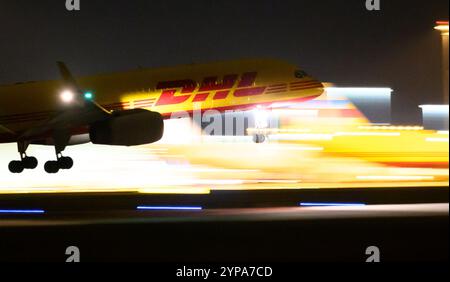 Leipzig, Deutschland. November 2024. Ein DHL-Flugzeug landet am späten Abend am DHL-Drehkreuz am Flughafen Leipzig/Halle. Mit dem Frachtzentrum der Post-Tochter DHL ist der Flughafen eines der weltweit wichtigsten Luftfrachtzentren. Quelle: Hendrik Schmidt/dpa/Alamy Live News Stockfoto