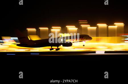 Leipzig, Deutschland. November 2024. Ein DHL-Flugzeug landet am späten Abend am DHL-Drehkreuz am Flughafen Leipzig/Halle. Mit dem Frachtzentrum der Post-Tochter DHL ist der Flughafen eines der weltweit wichtigsten Luftfrachtzentren. Quelle: Hendrik Schmidt/dpa/Alamy Live News Stockfoto