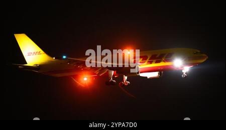 Leipzig, Deutschland. November 2024. Ein DHL-Flugzeug landet am späten Abend am DHL-Drehkreuz am Flughafen Leipzig/Halle. Mit dem Frachtzentrum der Post-Tochter DHL ist der Flughafen eines der weltweit wichtigsten Luftfrachtzentren. Quelle: Hendrik Schmidt/dpa/Alamy Live News Stockfoto