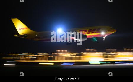 Leipzig, Deutschland. November 2024. Ein DHL-Flugzeug landet am späten Abend am DHL-Drehkreuz am Flughafen Leipzig/Halle. Mit dem Frachtzentrum der Post-Tochter DHL ist der Flughafen eines der weltweit wichtigsten Luftfrachtzentren. Quelle: Hendrik Schmidt/dpa/Alamy Live News Stockfoto
