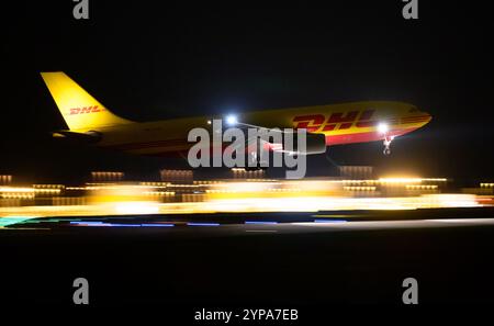 Leipzig, Deutschland. November 2024. Ein DHL-Flugzeug landet am späten Abend am DHL-Drehkreuz am Flughafen Leipzig/Halle. Mit dem Frachtzentrum der Post-Tochter DHL ist der Flughafen eines der weltweit wichtigsten Luftfrachtzentren. Quelle: Hendrik Schmidt/dpa/Alamy Live News Stockfoto