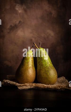 Ansicht von drei Birnen auf einem Tuch, dunkler Hintergrund Stockfoto