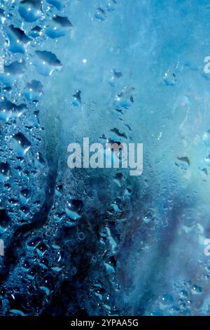 Deilcate Regentropfen Wasser auf Glas in einem blauen Glow für Hintergrund Stockfoto