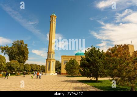 Vor einem Gebäude befindet sich ein hoher Turm mit einer blauen Kuppel Stockfoto