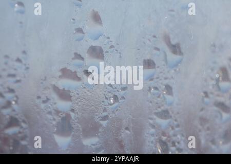 Deilcate Regentropfen Wasser auf Glas in einem blauen Glow für Hintergrund Stockfoto