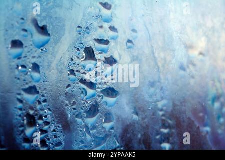 Deilcate Regentropfen Wasser auf Glas in einem blauen Glow für Hintergrund Stockfoto