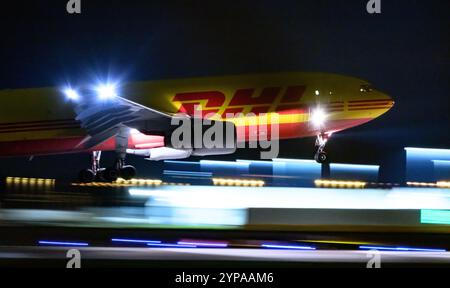 Leipzig, Deutschland. November 2024. Ein DHL-Flugzeug landet am späten Abend am DHL-Drehkreuz am Flughafen Leipzig/Halle. Mit dem Frachtzentrum der Post-Tochter DHL ist der Flughafen eines der weltweit wichtigsten Luftfrachtzentren. Quelle: Hendrik Schmidt/dpa/Alamy Live News Stockfoto