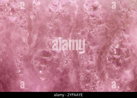 Deilcate Regentropfen Wasser auf Glas in einem rosa Glow für Hintergrund Stockfoto