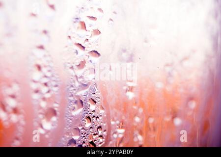 Deilcate Regentropfen Wasser auf Glas in einem rosa Glow für Hintergrund Stockfoto