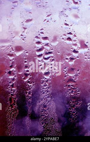 Deilcate Regentropfen Wasser auf Glas in einem rosa Glow für Hintergrund Stockfoto