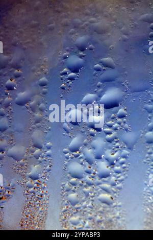 Deilcate Regentropfen Wasser auf Glas in einem blauen Glow für Hintergrund Stockfoto