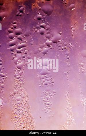 Deilcate Regentropfen Wasser auf Glas in einem rosa Glow für Hintergrund Stockfoto