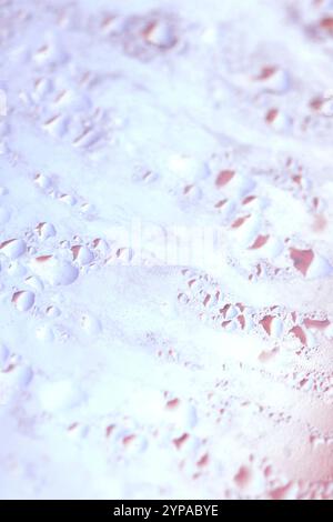 Deilcate Regentropfen Wasser auf Glas in einem rosa Glow für Hintergrund Stockfoto