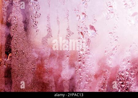Deilcate Regentropfen Wasser auf Glas in einem rosa Glow für Hintergrund Stockfoto