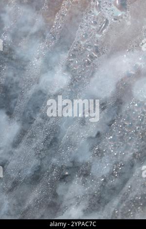 Deilcate Regentropfen Wasser auf Glas in einem blauen Glow für Hintergrund Stockfoto