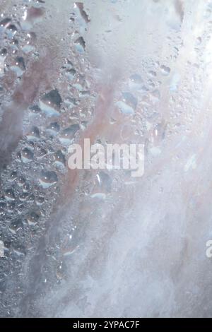 Deilcate Regentropfen Wasser auf Glas in einem blauen Glow für Hintergrund Stockfoto