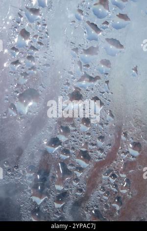Deilcate Regentropfen Wasser auf Glas in einem blauen Glow für Hintergrund Stockfoto