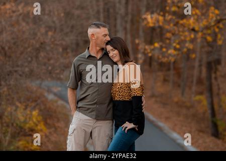 Ein Ehemann küsst im Herbst das Stirnporträt seiner Frau Stockfoto