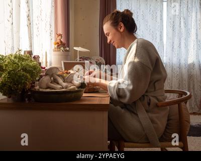 Horizontales Porträt einer Frau, die an ihrem Schreibtisch bastelt Stockfoto