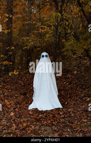 Ein Junge, der wie ein Geist gekleidet ist, mit einer Brille Stockfoto