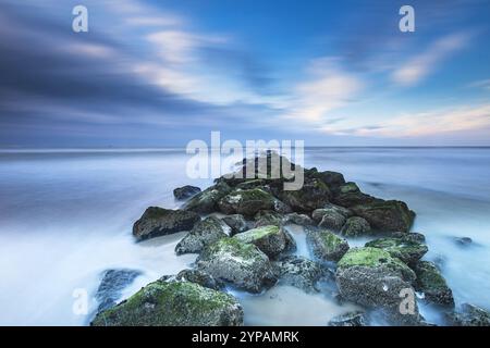 Surfwasser an einer Steinkippe an der Nordseeküste, Niederlande, Texel, Duenen von Texel Nationalpark Stockfoto