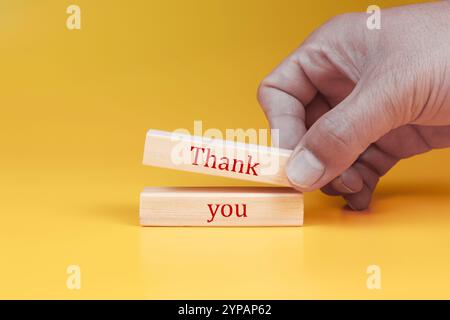 Dankeschön-Symbol. Holzblöcke mit Worten Danke. Schöner gelber Hintergrund. Business und Dankeschön Konzept. Kopierbereich. Stockfoto