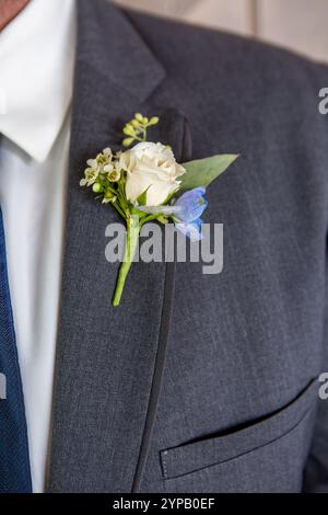 Hübscher Bräutigam in elegantem Anzug mit Blumenboutonniere am Hochzeitstag Stockfoto