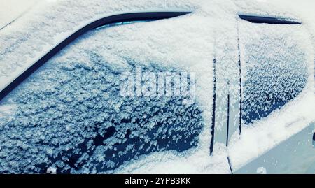 Nahaufnahme gefrorener Winterwagen mit Schnee, Seitenfenster auf schneebedecktem Hintergrund Stockfoto