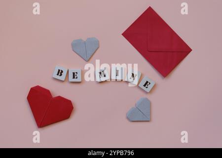 Origami-Herzen, roter Umschlag und „Be Mine“-Nachricht auf rosa Hintergrund Stockfoto