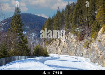 Schneebedeckte Bergstraße im Winter im Flathead National Forest, Montana, USA Stockfoto