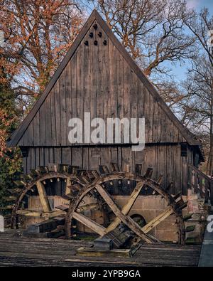 Eine wunderschön erhaltene historische Wassermühle in Lage, Deutschland, mit zwei Holzrädern und einer traditionellen Holz- und Ziegelkonstruktion in der Nähe einer fließenden Wassermühle Stockfoto