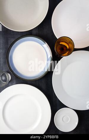 Draufsicht einer leeren Teller und Gläser auf schwarzem Hintergrund. Flache Lagen. Draufsicht. Lebensmittelkonzept. Stockfoto