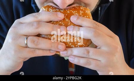 Hannover, Deutschland. November 2024. ILLUSTRATION - Ein Mann isst einen Burger Whopper in einem Restaurant der Fast-Food-Kette Burger King. Quelle: Julian Stratenschulte/dpa/Alamy Live News Stockfoto