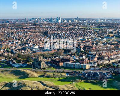 WALLASEY, MERSEYSIDE, ENGLAND - 27. NOVEMBER 2024: Wallasey Town mit St. Nicholas Church und Liverpool Skyline im Hintergrund, Wirral, England Stockfoto